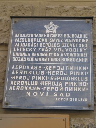 En skylt i Novi Sad på tre språk. Först serbiska med kyrillisk och latinsk text, därefter slovakiska, ungerska, rumänska samt ru